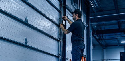 Technician servicing a commercial overhead door inside a warehouse